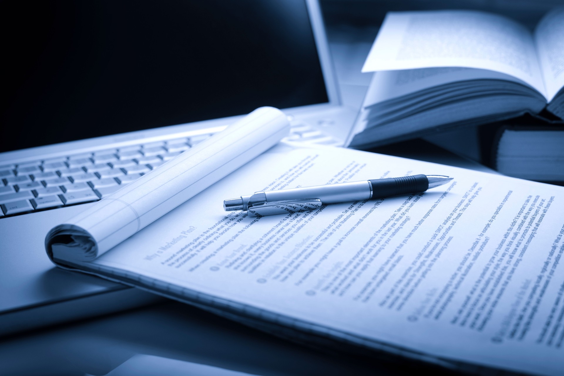 Laptop com livros, caneta e jurídico pad